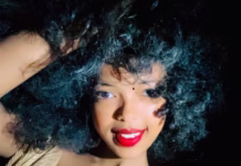 A young Ethiopian woman with curly hair posing elegantly.